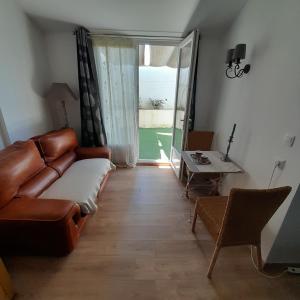 een woonkamer met een bank en een tafel bij L'olivier TESSA Hôtesse suite 30m2 terrasse 20m2 in La Celle