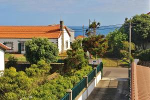 - Vistas a una casa con valla y árboles en Rib's House, en Praia da Vitória
