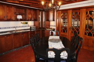 cocina con mesa, sillas y fregadero en Rib's House, en Praia da Vitória