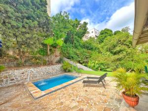 a swimming pool in a yard with a chair at Cozy House in Rio de Janeiro