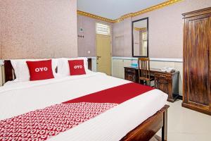 Postel nebo postele na pokoji v ubytování Hotel O Padang City Center Near Gunung Padang Formerly Hotel Fitriaendika