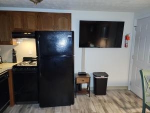 a kitchen with a black refrigerator and a stove at Nautical Mile Resort in Wells +4 photos