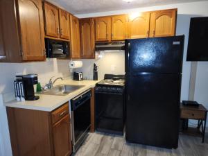 a kitchen with a black refrigerator and a sink at Nautical Mile Resort in Wells
