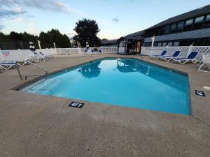 a large blue swimming pool with chairs and a building at Nautical Mile Resort in Wells