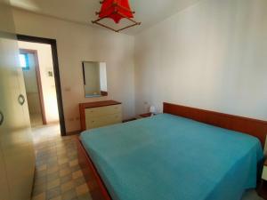 a bedroom with a blue bed and a mirror at La Casa del Marinaio P1 in San Foca
