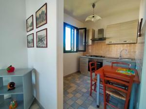 a kitchen with a red table and a kitchen counters at La Casa del Marinaio P1 in San Foca