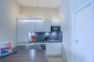 a kitchen with white cabinets and a wooden table at Marco Polo Suite - Komfort und Erholung zwischen Ostsee und Bodden in Wustrow