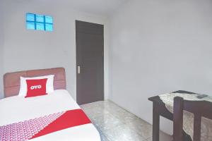a bedroom with a bed with a red pillow at Hotel O Borneo in Manado
