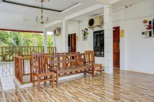 a room with two wooden benches on a porch at OYO Life 92021 Dua Putra Homestay Klayar in Watukarung