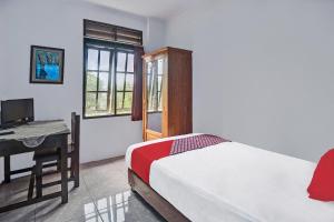 a bedroom with a bed and a desk with a computer at Hotel O Borneo in Manado +20 photos