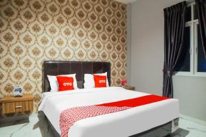 a bedroom with a large bed with red pillows at SUPER OYO Capital O 92066 Papakoel Hotel & Cafe in Medan
