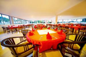 een restaurant met rode tafels en stoelen met rode servetten erop bij Katomi Kingdom Resort Entebbe in Entebbe