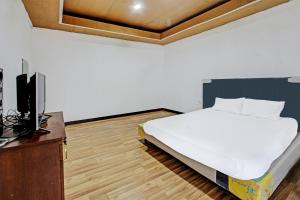 a bedroom with a bed and a tv in it at Hotel O Panorama Rinjani LodgeNearTaman Nasional Gunung Rinjani in Labuan Lombok