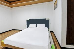 a bedroom with a white bed in a room at Hotel O Panorama Rinjani LodgeNearTaman Nasional Gunung Rinjani in Labuan Lombok