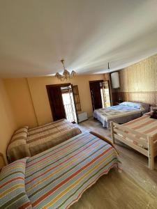 a bedroom with two beds and a couch and a chandelier at La casa de Felipe y Paquita in Guadix