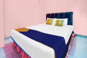 a large bed with yellow and blue pillows on it at OYO Life 92046 Garuda Residence in Palembang +19 photos
