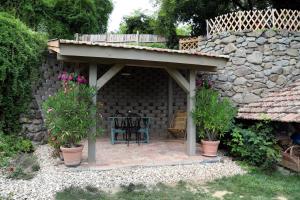 a patio with a roof and a table and chairs at Templomdomb Vendégház Dunakanyar in Pilismarót