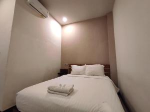 a bedroom with a bed with two towels on it at Hotel O Subur in Cimpu
