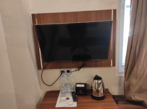 a flat screen television hanging on a wall at Hotel O Subur in Cimpu