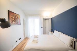 a bedroom with a large white bed with a blue wall at Elegante Appartamento nel Cuore dei Navigli in Milan