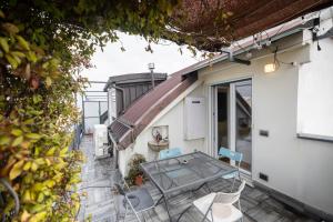a small balcony with a glass table and chairs at Elegante Appartamento nel Cuore dei Navigli in Milan