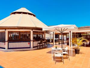 a restaurant with tables and umbrellas on a patio at Sunset Taurito in Taurito
