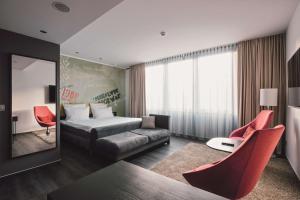 ein Hotelzimmer mit einem Bett und roten Stühlen in der Unterkunft Hotel Berlin, Berlin, a member of Radisson Individuals in Berlin