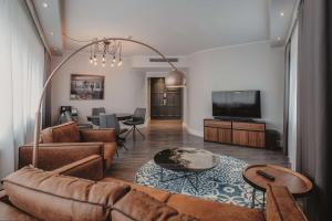 ein Wohnzimmer mit Couch und Flachbildfernseher in der Unterkunft Hotel Berlin, Berlin, a member of Radisson Individuals in Berlin