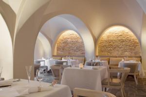 a restaurant with white tables and chairs and arches at Anassa in Polis Chrysochous