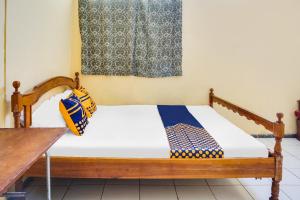 una camera da letto con un letto di legno e una finestra di OYO Life 92087 Griya Nurainy a Pasuruan Altre 17 foto