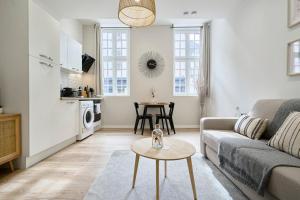 a living room with a couch and a table at Studio confort Equipé & Connecté - 1 - Mon Groom in Troyes