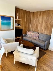 a living room with a couch and a table at Lou Le Lavandou in De Panne