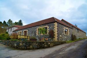 una casa in pietra sul lato di una strada di The Steadings Log Cabins a Kettlebridge