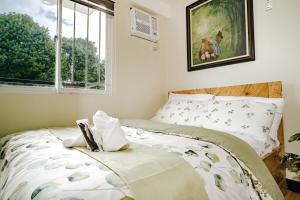 a bedroom with a bed and a window with a picture at AR09 HBRentals 1BR Smart Unit in Davao City +27 photos