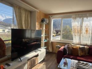 a living room with a large flat screen tv at Bahnhof West Apartments in Interlaken