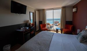 a hotel room with a bed and a view of the ocean at LOGIS HOTEL - La Petite Rade in Le Havre
