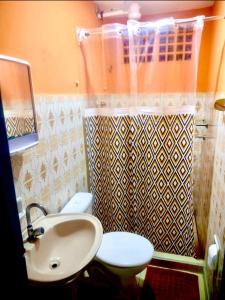 a bathroom with a white toilet and a sink at Guest House Rosa do Mar in Olinda