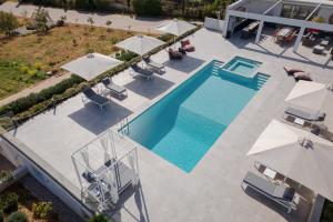 an overhead view of a swimming pool with umbrellas at Ema's Guest House in Porto Rafti