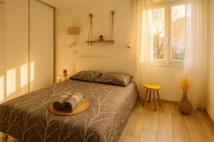 a bedroom with a bed with a hat on it at "COSY" Appartement confort de 50m2 à 150m de la Mer et du Centre ville, parking gratuit in Canet-en-Roussillon