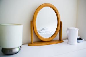 a wooden mirror on a shelf in a room at New Snug DoubleEnsuite in Central Forest Row in Forest Row
