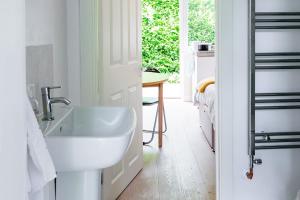 a white bathroom with a sink and a table at New Snug DoubleEnsuite in Central Forest Row in Forest Row