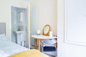 a bedroom with a table and a mirror and a bed at New Snug DoubleEnsuite in Central Forest Row in Forest Row