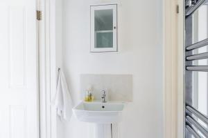 a white bathroom with a sink and a mirror at New Snug DoubleEnsuite in Central Forest Row in Forest Row