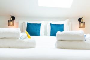 a bedroom with a white bed with blue pillows at Nid douillet sous les combles in Châlons-en-Champagne