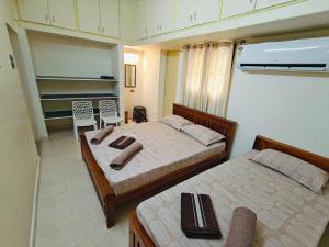 a bedroom with two beds and a table and chairs at Jayam Home Stays in Tiruvannāmalai