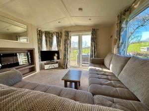 a living room with a couch and a television at Fallow Cabin in Pilsdon