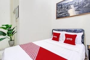 a bedroom with a bed with two red pillows at OYO Life 92184 Mr Brown Homestay in Rembang