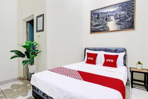 a bedroom with a bed with two red pillows at OYO Life 92184 Mr Brown Homestay in Rembang +19 photos