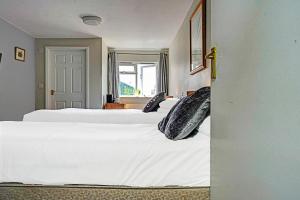a bedroom with two beds with white sheets and pillows at The Billingford Horseshoes in Scole +21 photos