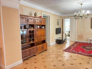 a living room with a large wooden entertainment center at Cozy 5BD House With Frontyard in Tbilisi City